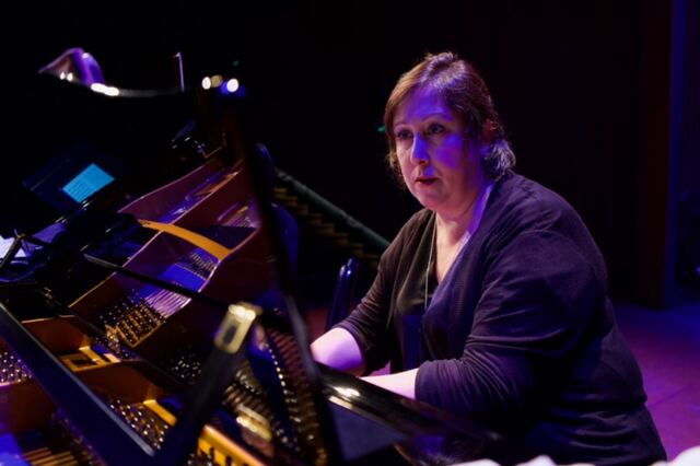 Marcela Rodríguez al piano, bajo luz violeta